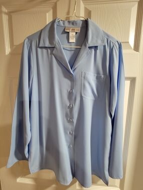 Light blue Susan Graver Style shirt. Has long sleeves and a button up-size XS